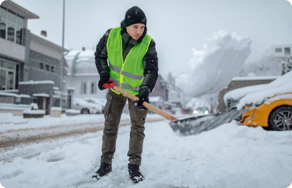Man shoveling snow off a street