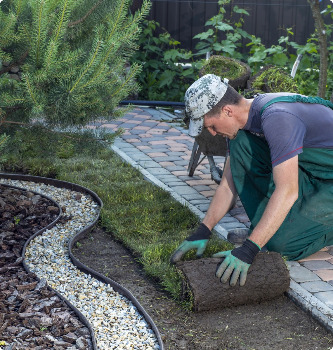 Man installing grass turf outdoors